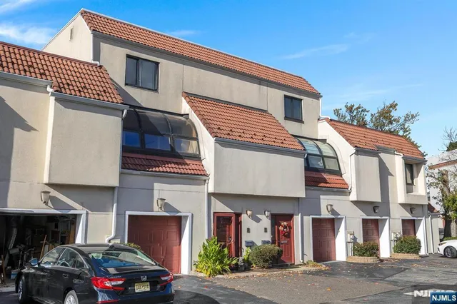 a front view of a house with cars parked