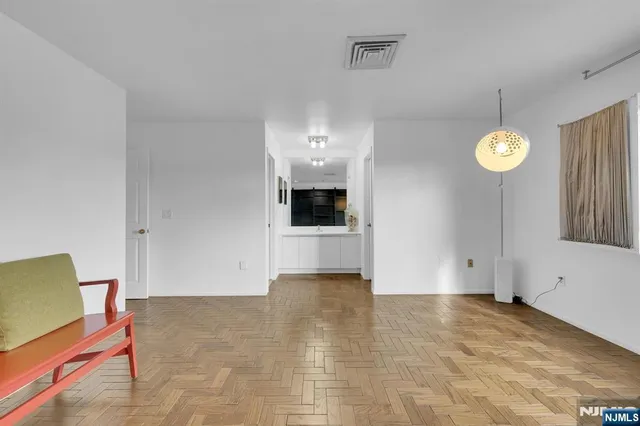 a view of a livingroom with wooden floor and a large window