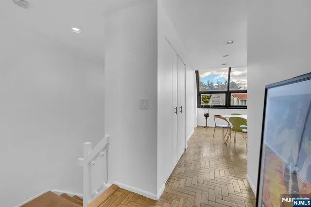 a view of a hallway with furniture and a window