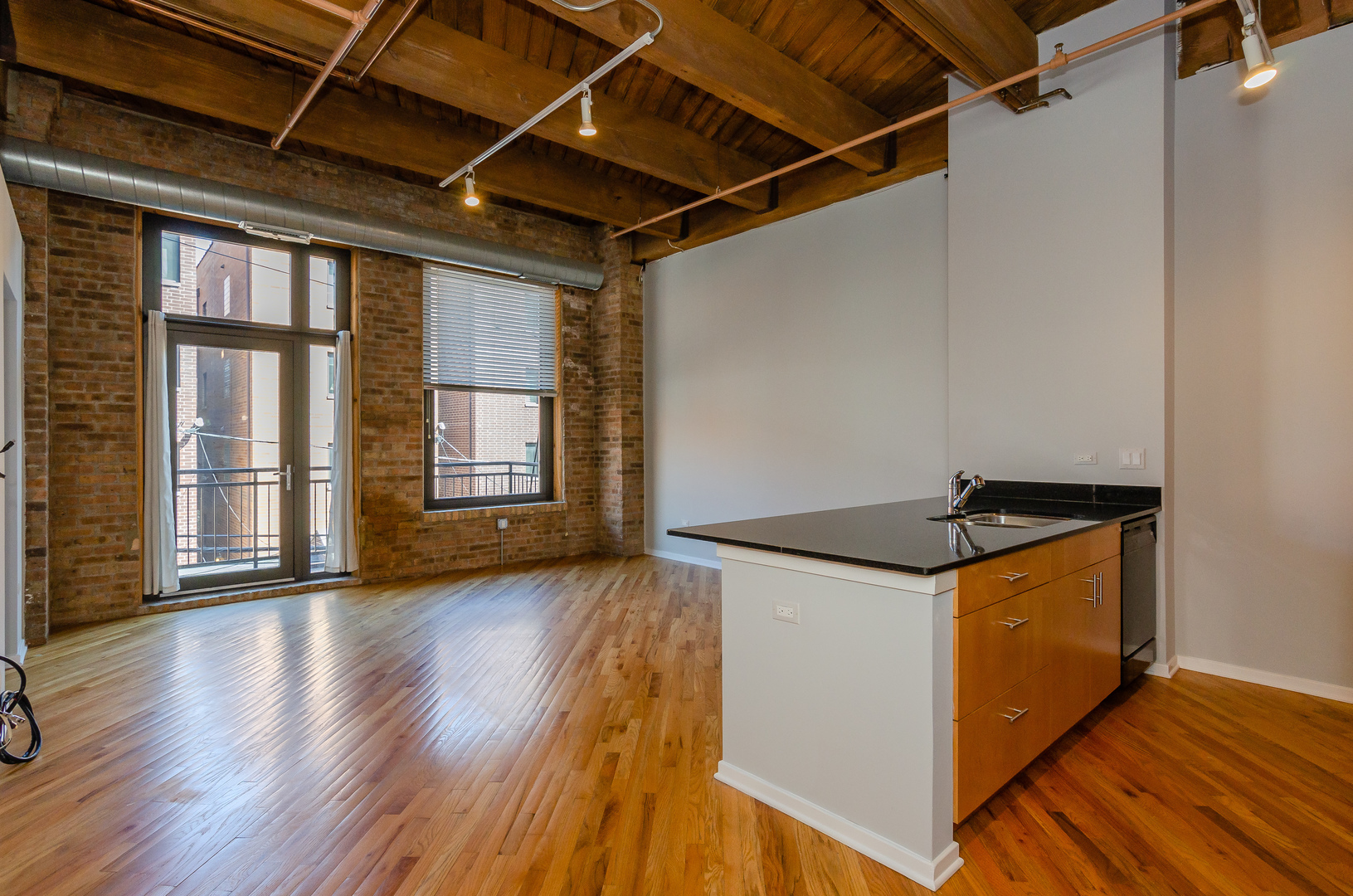 1040 West Adams Street, Unit 257 Chicago, IL 60607 - Photo 6 of 15 a kitchen with granite countertop a stove and wooden floor
