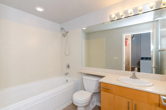 a bathroom with a granite countertop sink a toilet and a bathtub