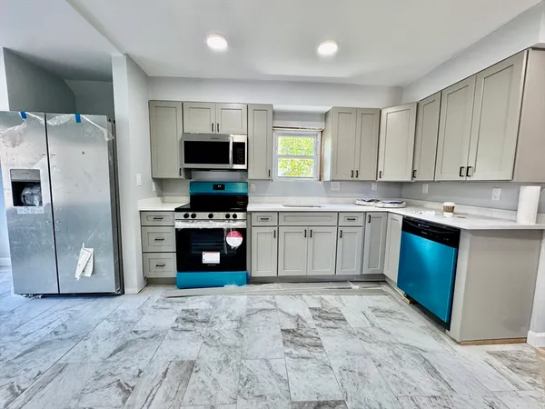 a kitchen with stainless steel appliances granite countertop a stove a sink and a refrigerator