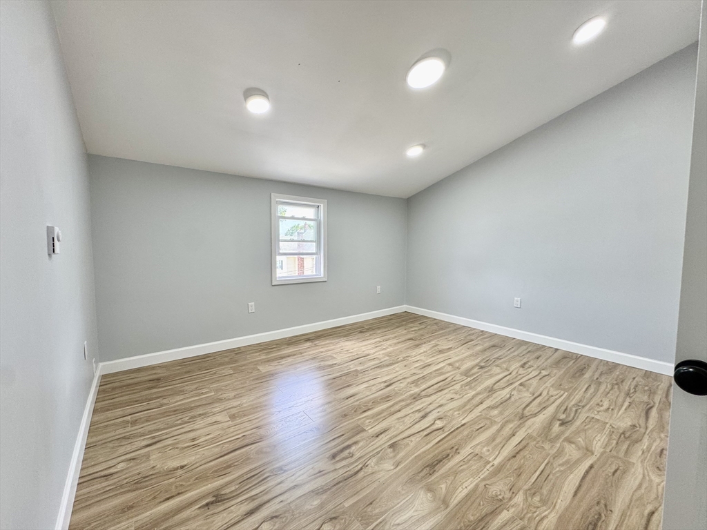 201 Belmont Street, Unit 2 Everett, MA 02149 - Photo 12 of 19 an empty room with wooden floor and windows