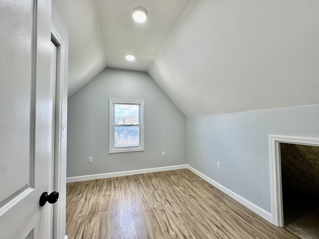 201 Belmont Street, Unit 2 Everett, MA 02149 - Photo 13 of 19 a view of an empty room with wooden floor and a window