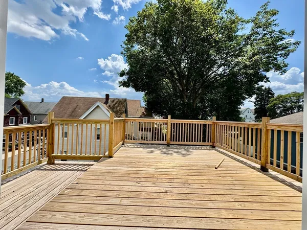 a view of a wooden deck and a yard with swimming pool