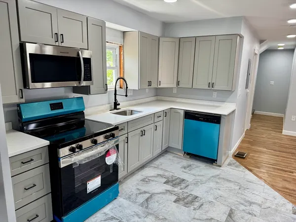 a kitchen with stainless steel appliances a stove microwave and sink