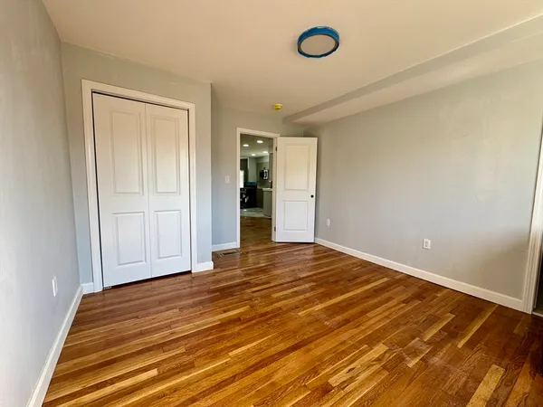 an empty room with wooden floor and closet