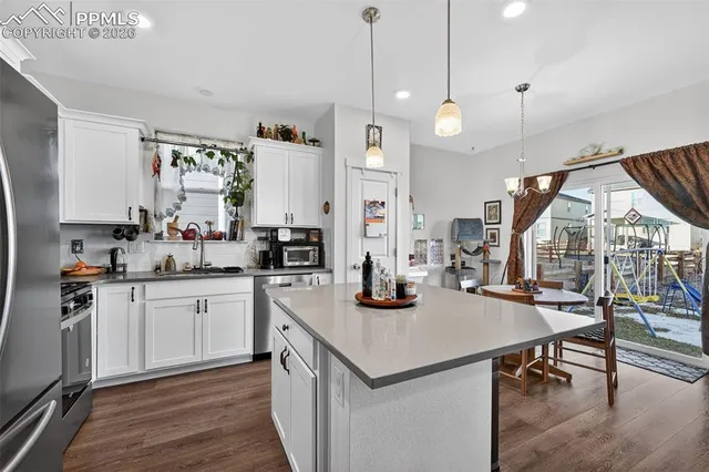 a kitchen with sink cabinets and wooden floor