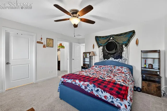 a bedroom with a bed a dresser and potted plants
