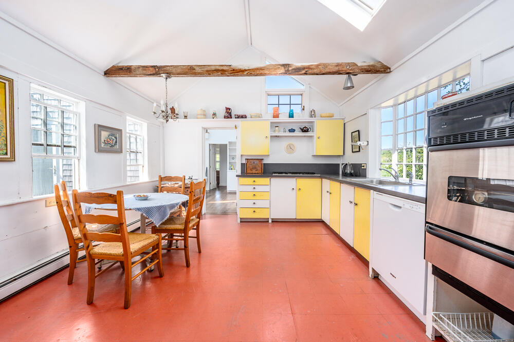 46 South Pamet Road Truro, MA 02666 - Photo 25 of 68 a kitchen with stainless steel appliances a table and chairs in it