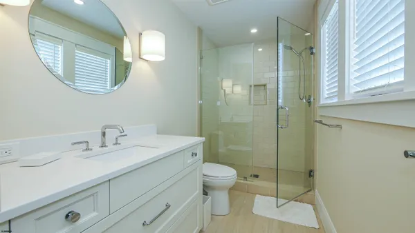 a bathroom with a granite countertop sink toilet and shower
