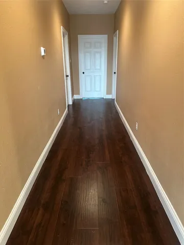 a view of a hallway with wooden floor