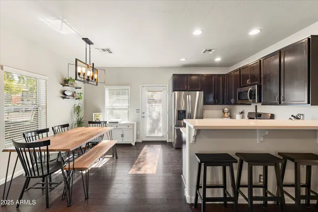 a kitchen with a table chairs refrigerator and microwave