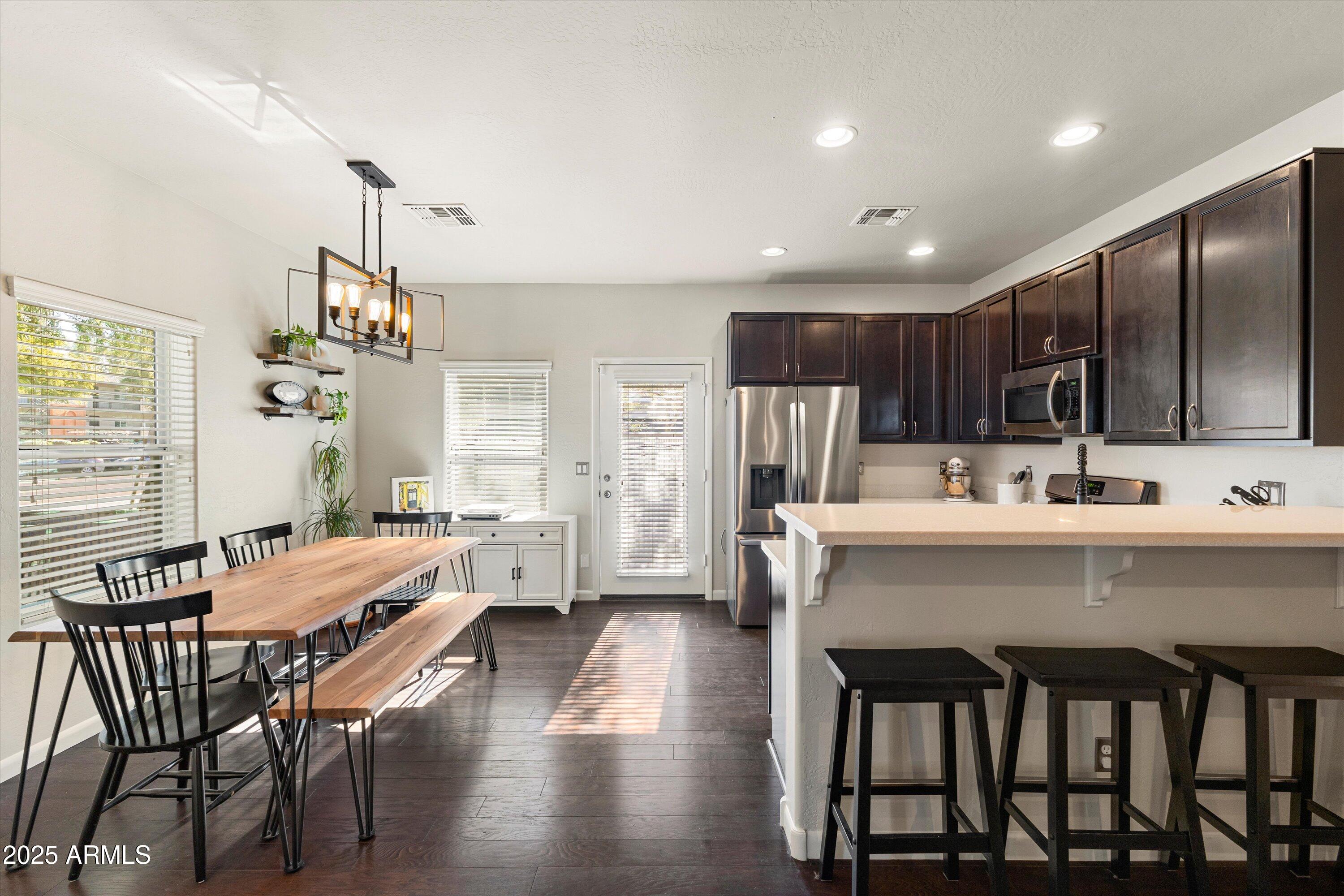 3930 North 30th Street Phoenix, AZ 85016 - Photo 12 of 40 a kitchen with a table chairs refrigerator and microwave
