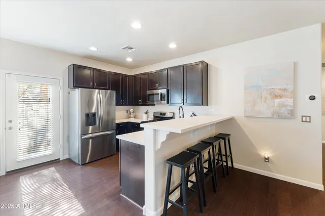a kitchen with refrigerator cabinets and wooden floor