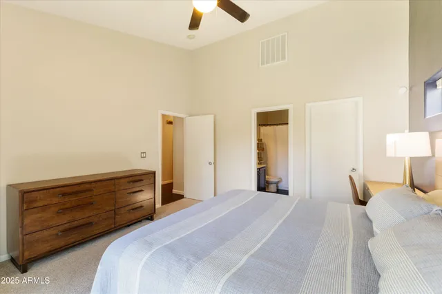 a bedroom with a bed and a lamp on dresser