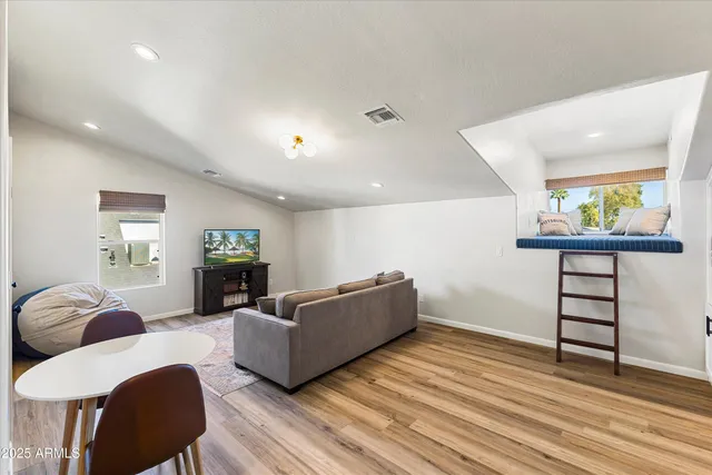 a living room with furniture and a wooden floor