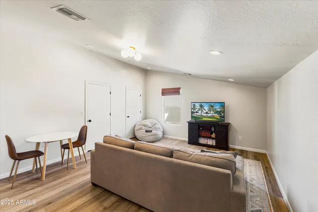 a living room with furniture a flat screen tv and a fireplace