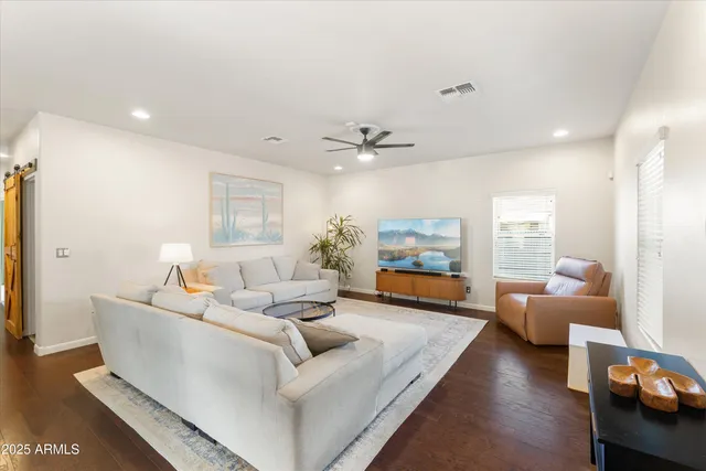 a living room with furniture and a wooden floor
