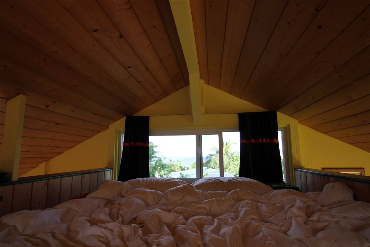 434 Hoolawa Road Haiku, HI 96708 - Photo 15 of 22 a bedroom with a bed and large windows