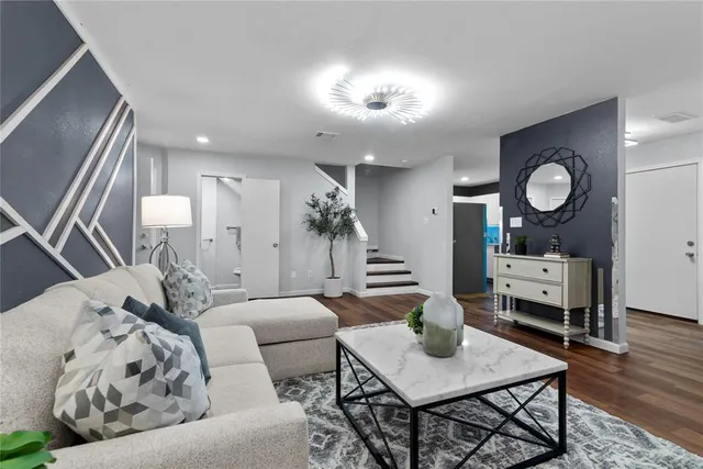 a living room with furniture and a view of kitchen