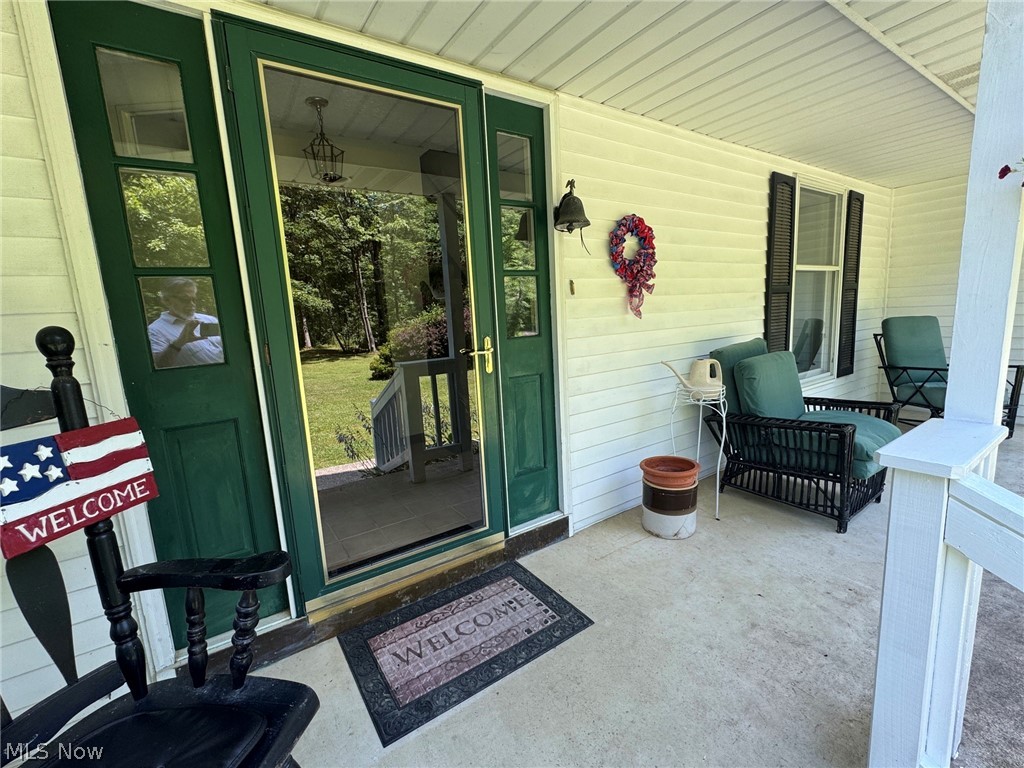 8201 Orchard Road Painesville, OH 44077 - Photo 5 of 45 Inviting front porch featuring a green entry door with a storm door and aluminum siding