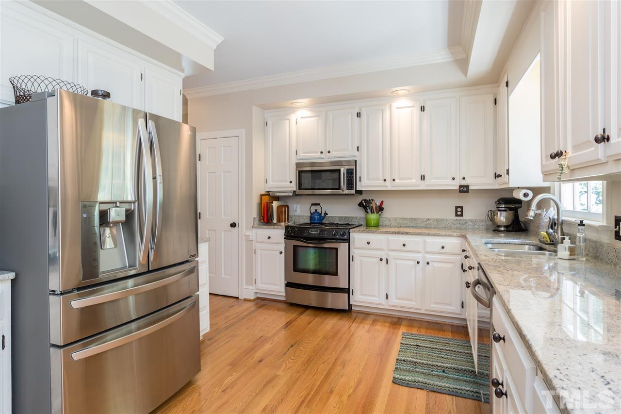2206 Oxford Road Raleigh, NC 27608 - Photo 7 of 25 a kitchen with stainless steel appliances and wooden cabinets