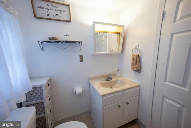 a bathroom with a toilet sink vanity and mirror