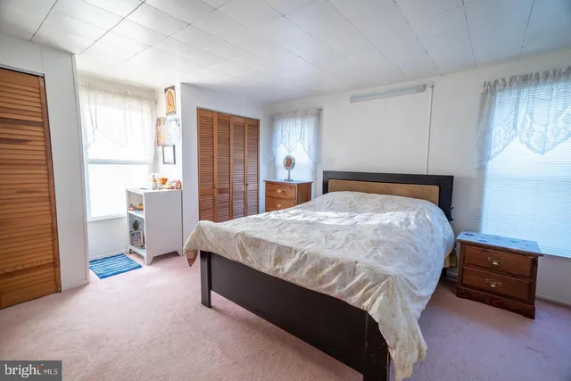 a bed sitting in a bedroom and table chair