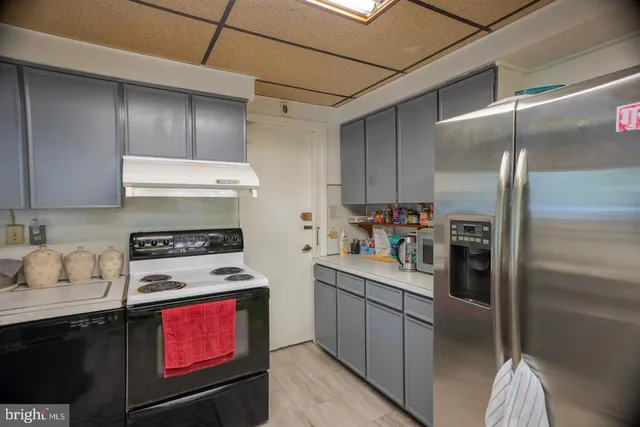 a kitchen with stainless steel appliances granite countertop a refrigerator a stove and a sink