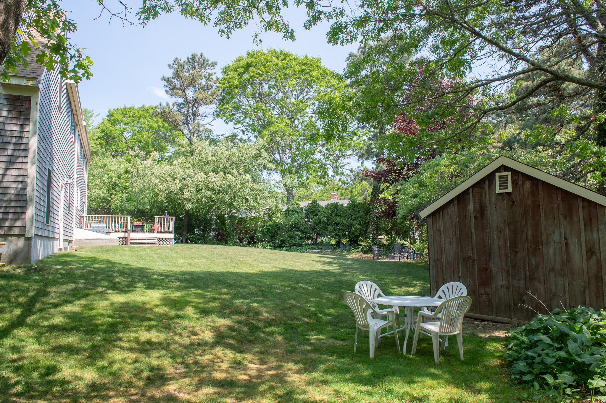 8 Yachtsman Circle Mashpee, MA 02649 - Photo 40 of 56 a backyard of a house with table and chairs