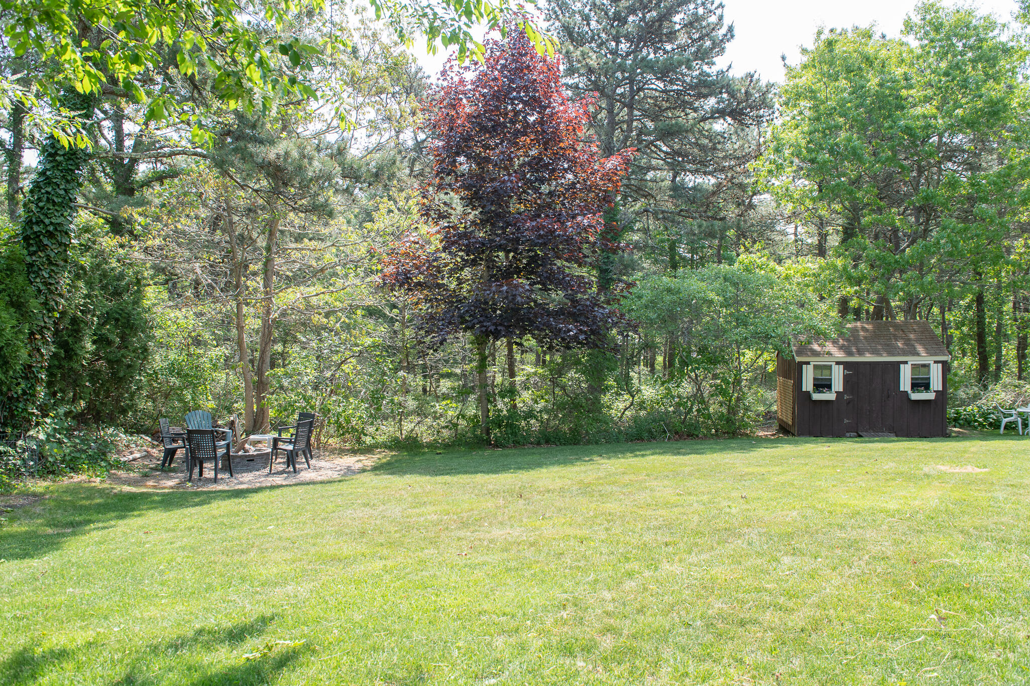 8 Yachtsman Circle Mashpee, MA 02649 - Photo 43 of 56 a backyard of a house with table and chairs