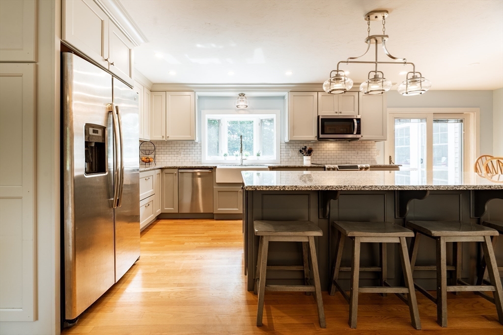 17 Gardner Road Duxbury, MA 02332 - Photo 10 of 42 a kitchen with kitchen island granite countertop wooden floor and stainless steel appliances