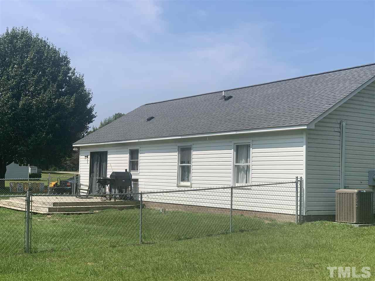 321 Jeribec Drive Willow Spring, NC 27592 - Photo 2 of 21 a view of a patio with table and chairs potted plants and large tree