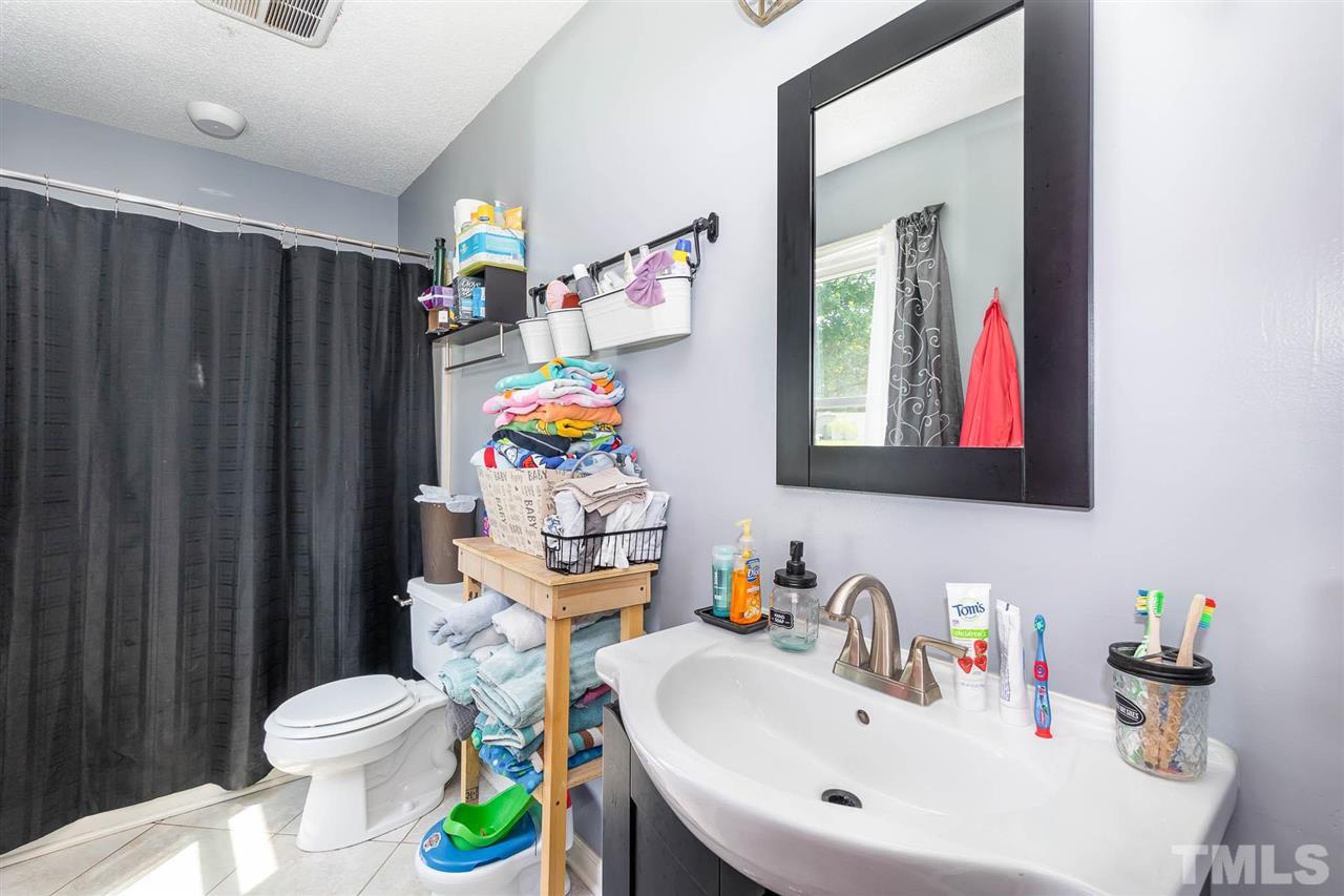 321 Jeribec Drive Willow Spring, NC 27592 - Photo 7 of 21 a bathroom with a sink a toilet and a mirror