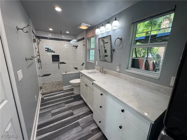 a bathroom with a sink a toilet and mirror