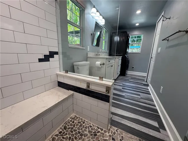 a spacious bathroom with a toilet sink and mirror