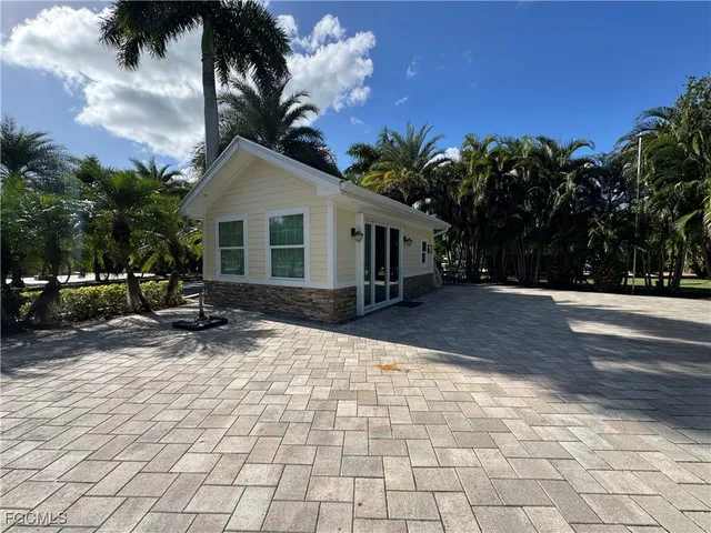 a living room with furniture a large window wooden floor and a rug