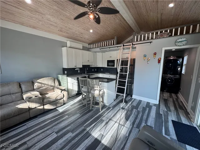 a living room with furniture a flat screen tv and a large window