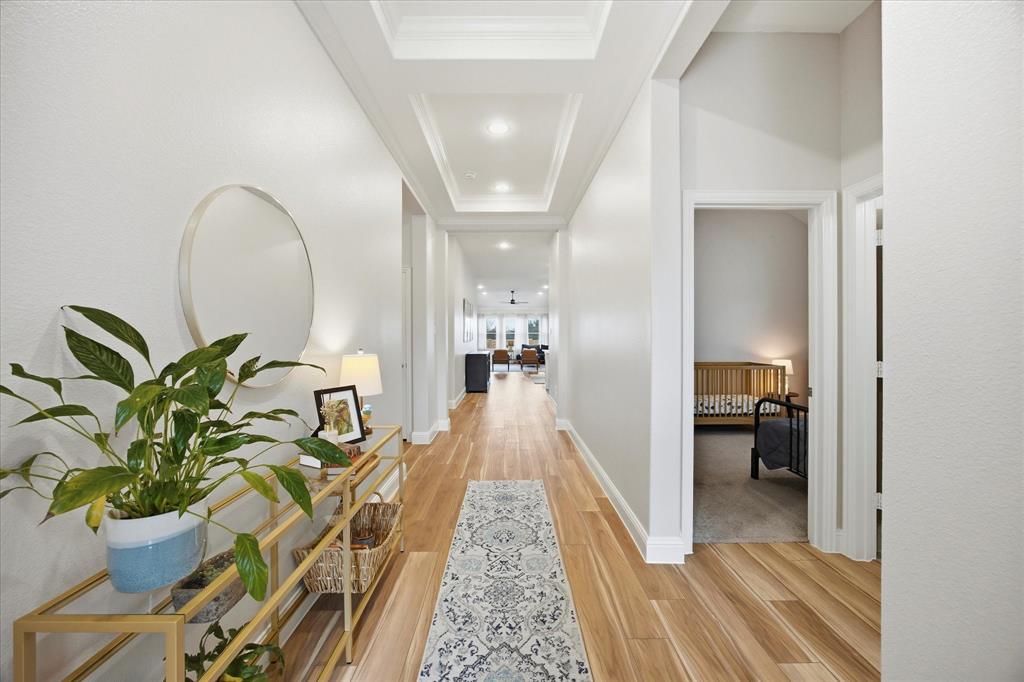 809 Mildren Lane Fate, TX 75087 - Photo 2 of 32 Entry hallway is a great width and length. Easy to decorate and make an impact when you walk in the front door. Look at that stepped tray ceiling! It is lovely!