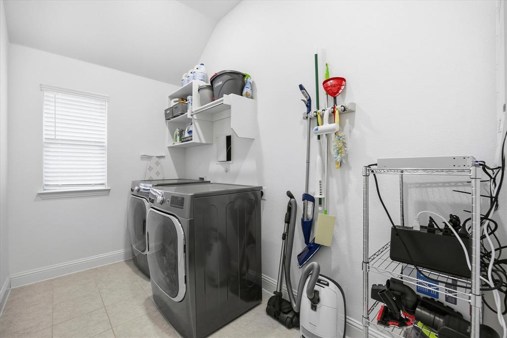 809 Mildren Lane Fate, TX 75087 - Photo 22 of 32 Spacious laundry room with built in shelves above the washer and dryer.