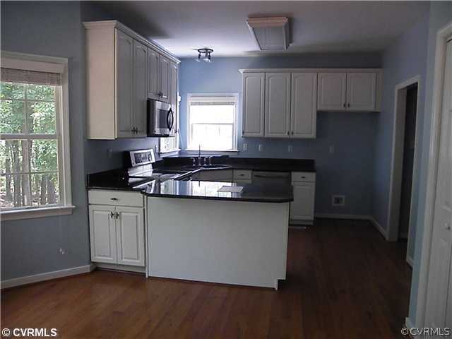 21810 Sappony Road Moseley, VA 23120 - Photo 12 of 24 a kitchen with granite countertop a sink stove and cabinets