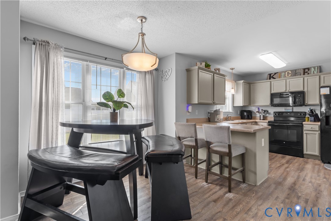 3363 Darbytown Road Henrico, VA 23231 - Photo 15 of 33 a kitchen with stainless steel appliances a table chairs refrigerator and microwave