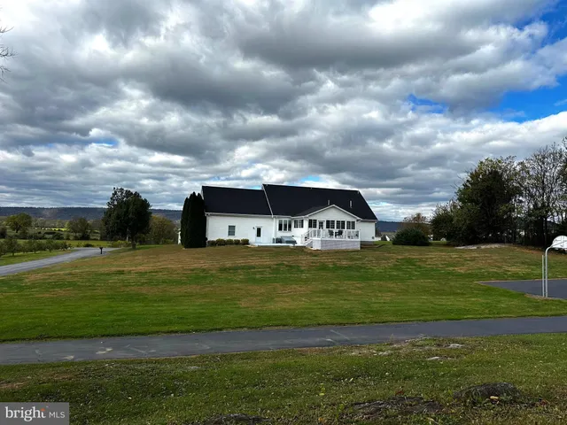 a view of a house with a yard and large trees