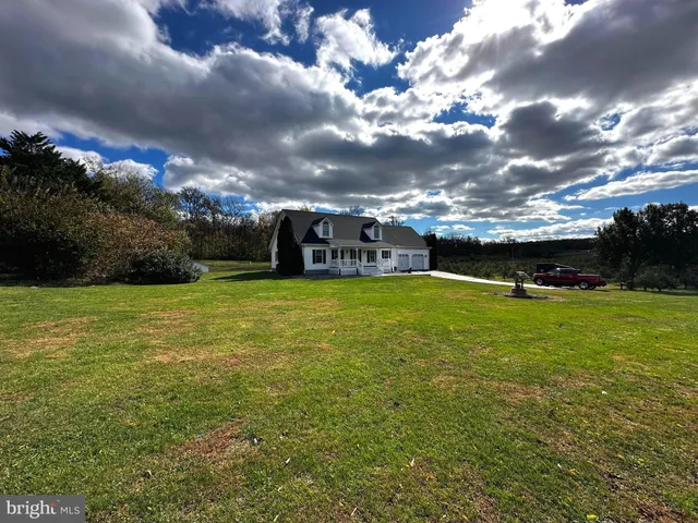 a view of a green field with house in the background
