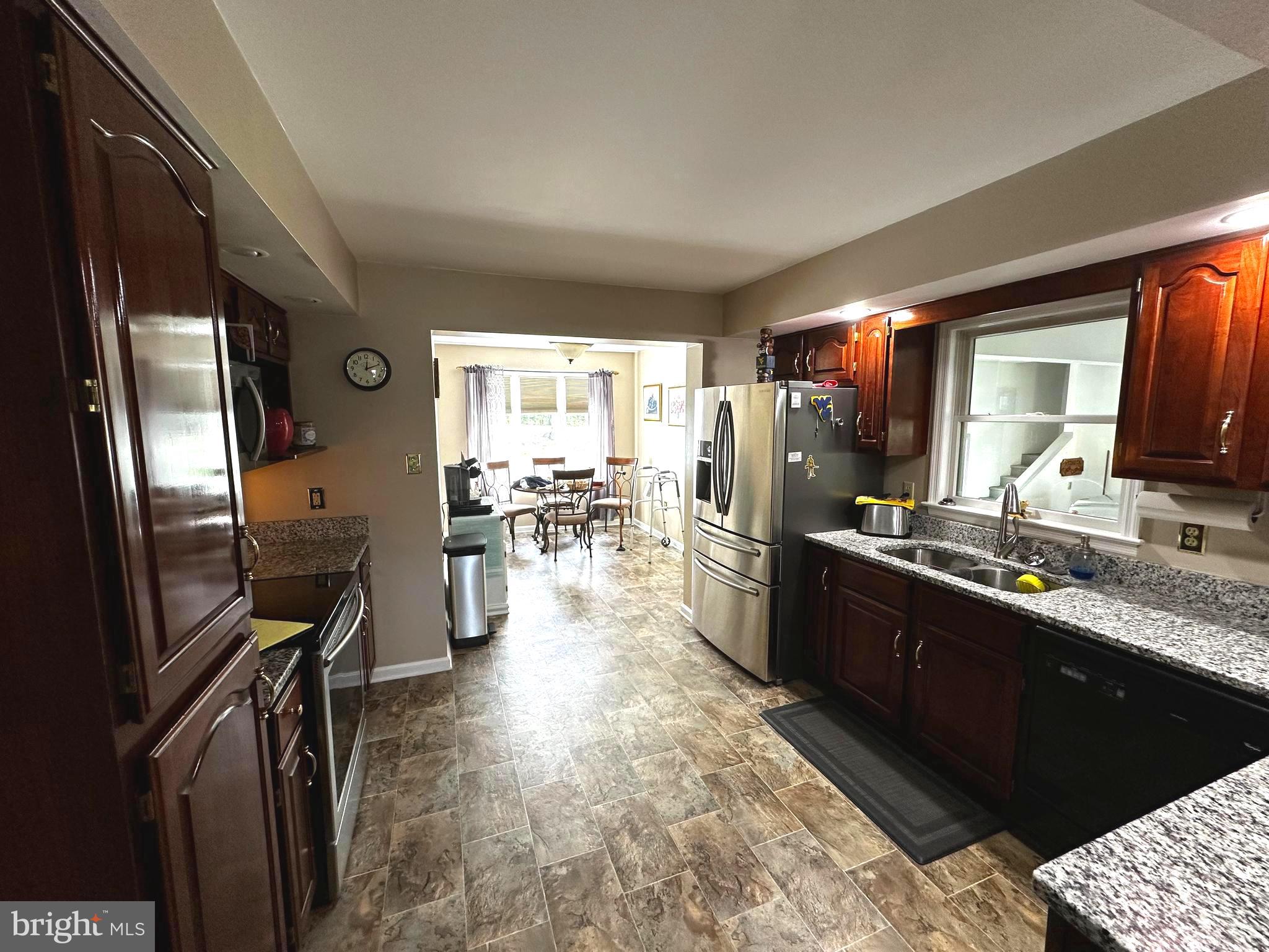 25 Mish Road Bunker Hill, WV 25413 - Photo 49 of 87 a kitchen with stainless steel appliances kitchen island granite countertop a refrigerator oven a sink dishwasher and wooden cabinets with wooden floor