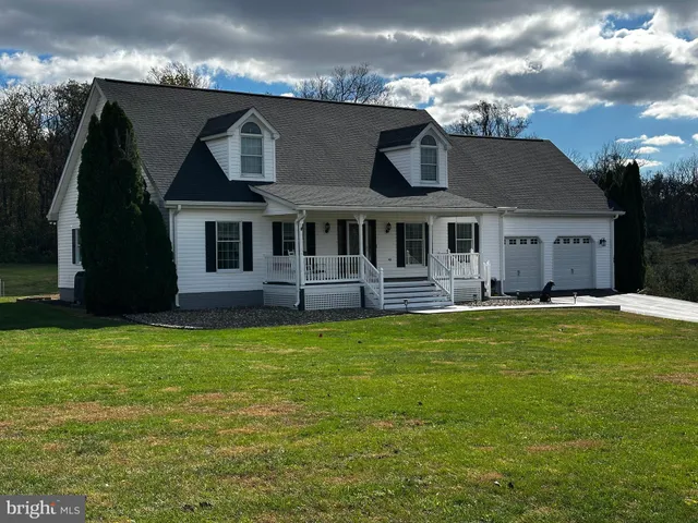 a view of a house with a big yard and a large tree