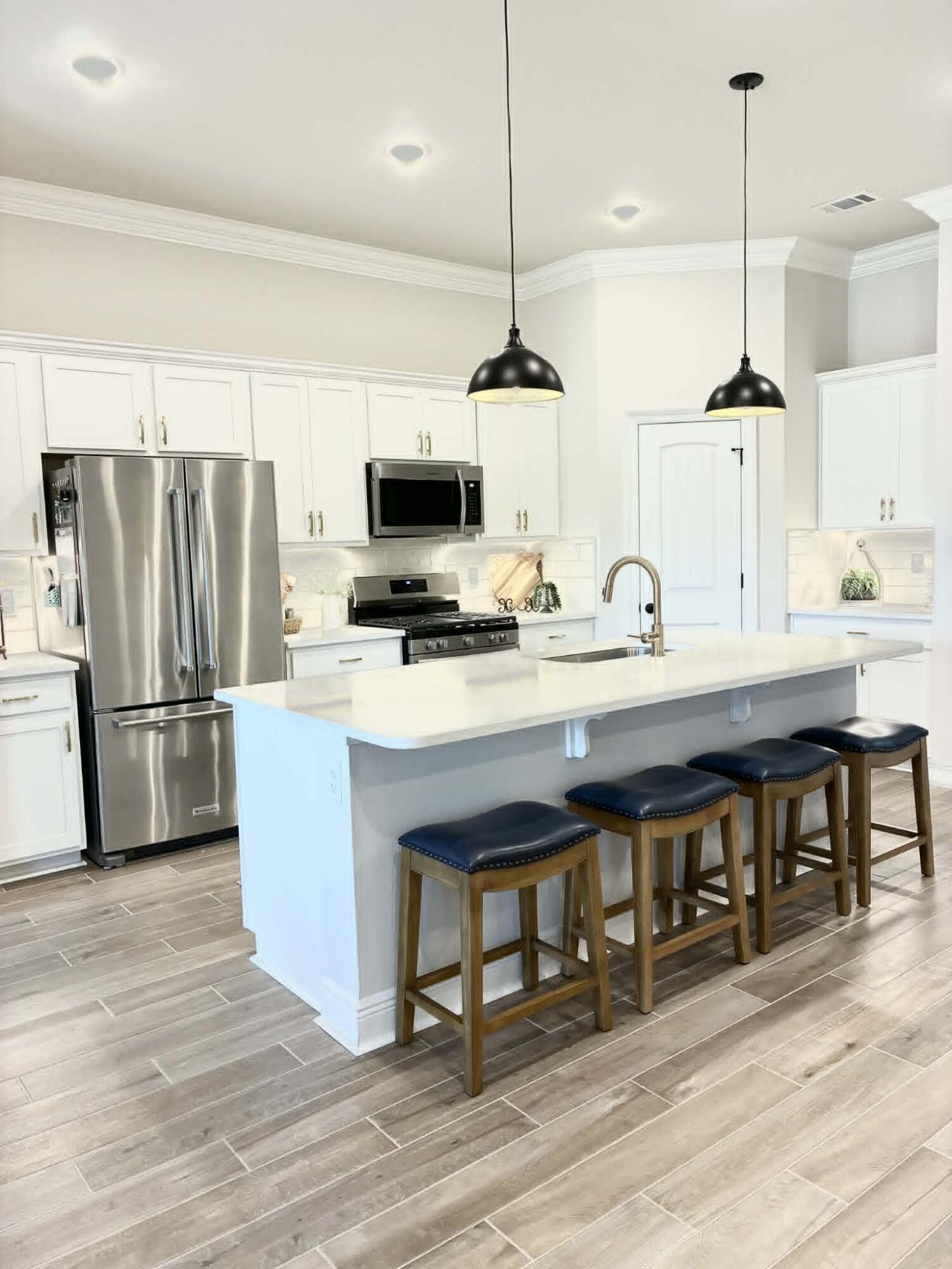 225 Hydrangea Boulevard Freeport, FL 32439 - Photo 2 of 11 a kitchen with a table chairs refrigerator and microwave