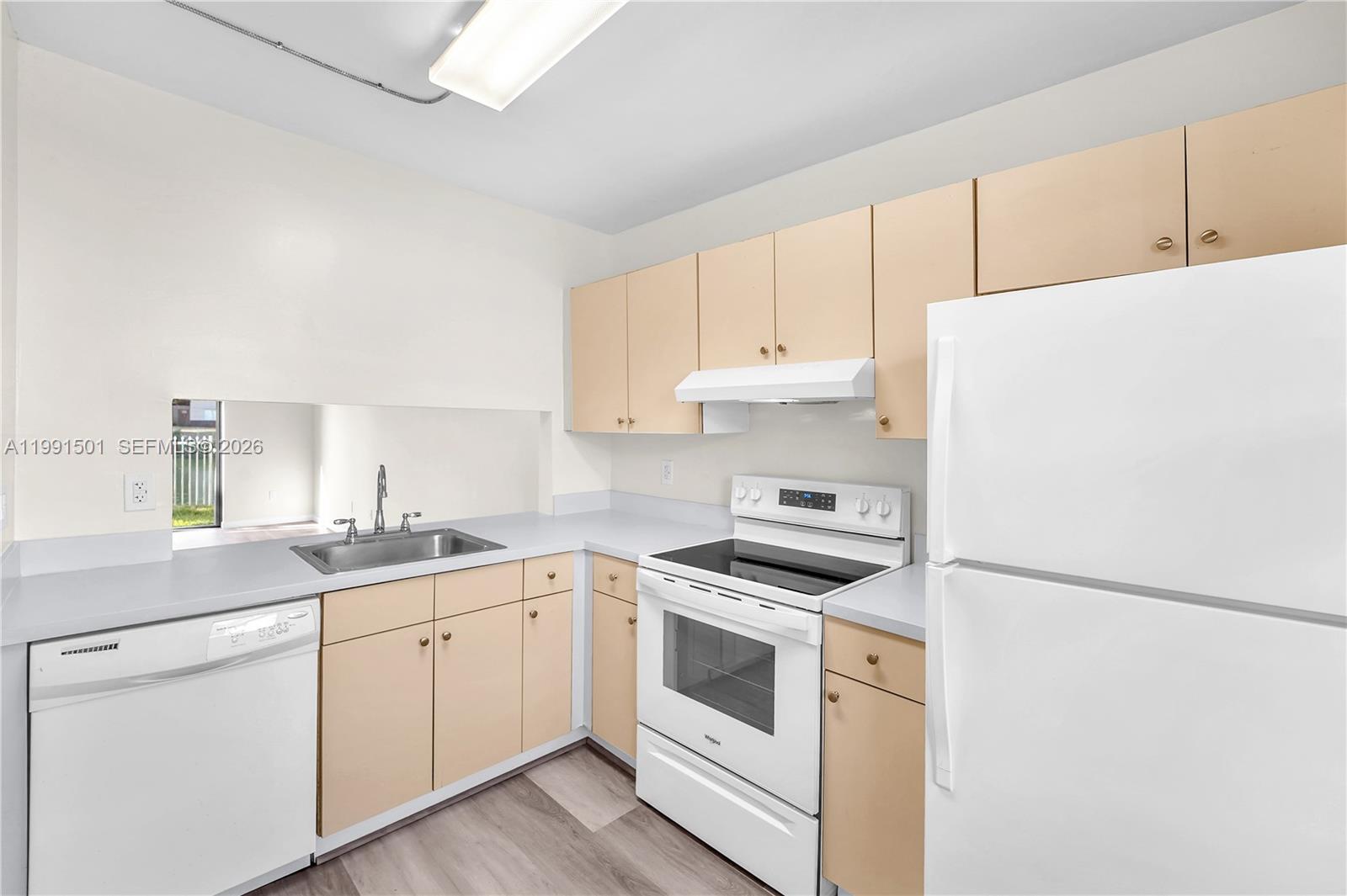 7668 Southwest 152nd Avenue, Unit 2107 Miami, FL 33193 - Photo 13 of 17 a kitchen with cabinets appliances a sink and a window