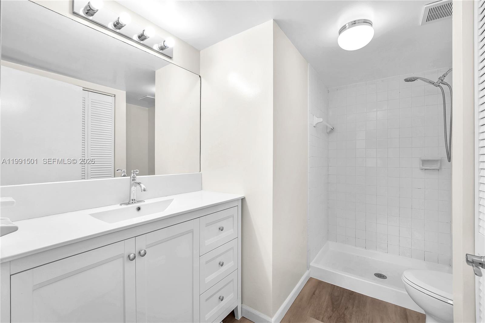 7668 Southwest 152nd Avenue, Unit 2107 Miami, FL 33193 - Photo 16 of 17 a bathroom with a tub sink mirror and a shower